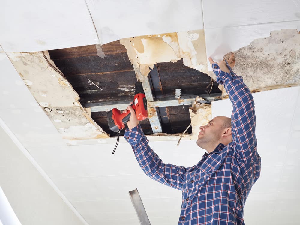 Ceiling with visible water stains and sagging areas, indicative of water damage restoration.